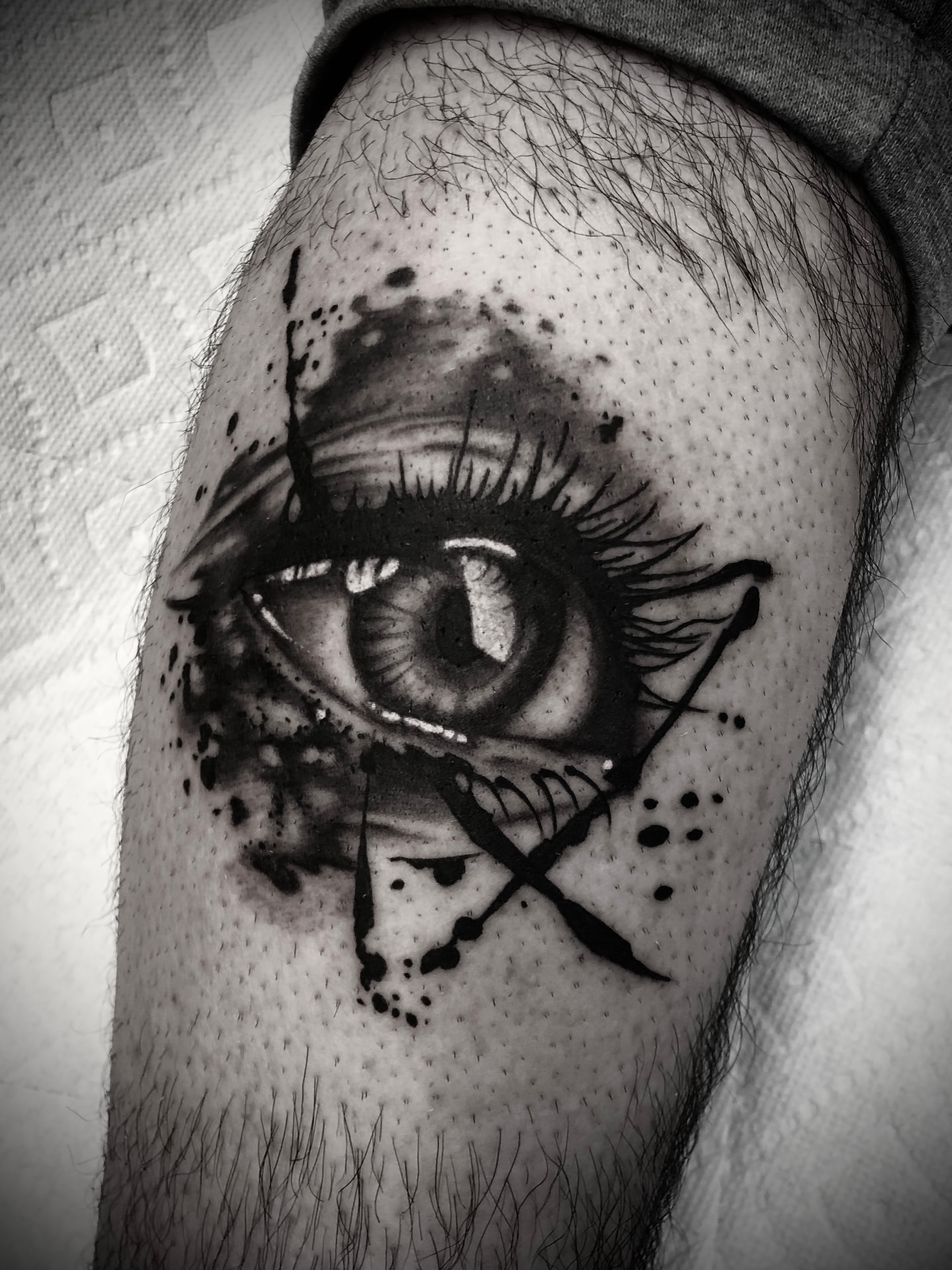 Realistic eye tattoo with ink splatter